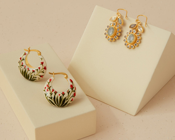 Two pairs of earrings with floral motifs.